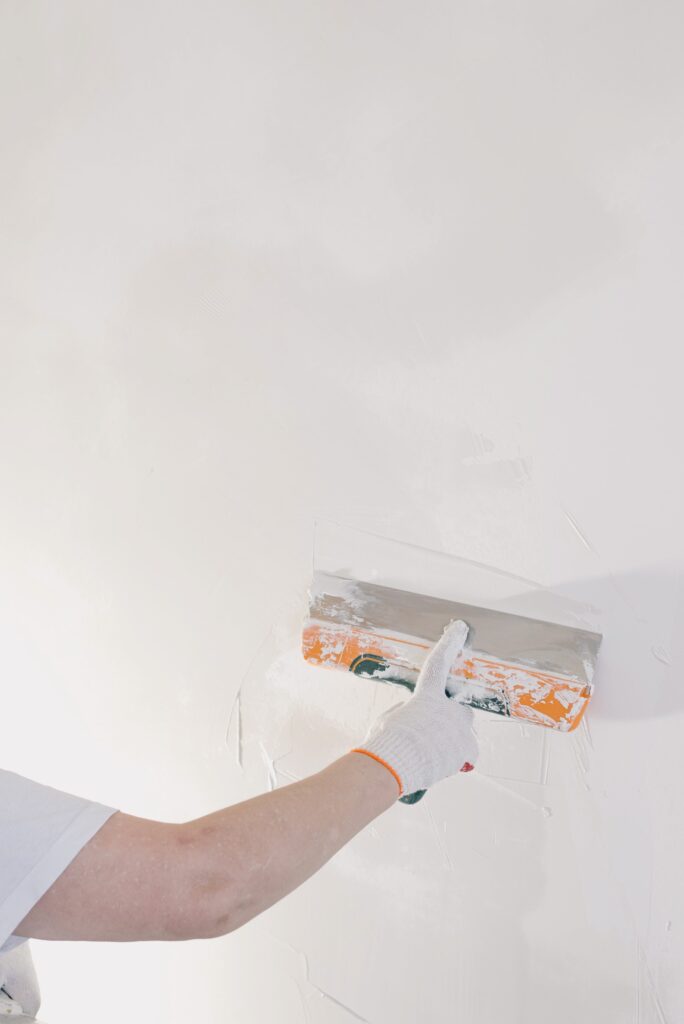 worker applying drywall